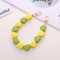 Dettaglio di perline acriliche a forma di cuore gialle e verdi con chiusura a moschettone - Verde e Giallo