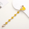 Détail d'un pendentif cœur jaune avec des maillons en émail doré et fermoir magnétique - Bracelet / Jaune