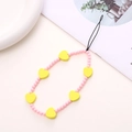 Detailed view of pink round beads and yellow heart charms on a beaded phone wrist strap - Yellow Wooden Heart