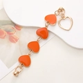 Détail des breloques cœur orange en émail sur une chaîne dorée avec fermoir magnétique - Bracelet Cœur Émaillé / Orange