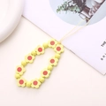 Close-up of yellow wooden flower beads and round pearls on a handmade phone wrist strap - Yellow Wooden Flower