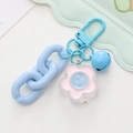 Close-up of a cute keychain with a pink acrylic flower, blue bell, and plastic chain - Lake Blue Chain Flower