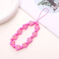 Detailed view of pink wooden flower beads and round pearls on a beaded phone wrist strap - Rose Red Wooden Flower