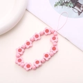 Detailed view of handmade pink wooden flower beads on a durable phone wrist strap - Pink Wooden Flower