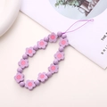 Detailed view of purple floral beaded phone charm with pastel aesthetic on a magazine - Purple Wooden Flower