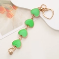 Détail d'une chaîne de téléphone dorée avec quatre cœurs en émail vert et fermoir - Bracelet Cœur Émaillé / Vert