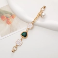 Detail of golden metal phone chain with green heart gemstone and white camellia charms - Green