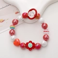 Detail of colorful beaded phone strap with red hearts and floral charms on a white stand - Red Flower