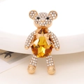 Macro shot of teddy bear brooch with yellow pear-cut crystal and sparkling rhinestones - Golden Yellow Gemstone