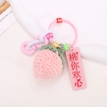 Detail of handmade crochet peach keychain with pink acrylic tag and colored alphabet beads - Peach Style