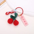 Detail of handmade crochet cherry keychain with red yarn berries and green leaves - Cherry Style