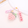Close-up of pink handmade knitted strawberry pendant with beaded chain and charm - Pink Strawberry Style