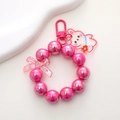 Detail of pink pearlescent beaded keychain with acrylic rabbit and butterfly charms - Rose Red
