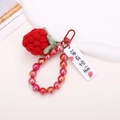 Close-up of handmade crochet strawberry keychain with red bead chain and metal clasp - Beaded Red Strawberry Style