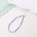 Detail of blue and white beaded phone strap with star and cloud charms on white tray - Phone Chain / K1070 Ceramic-Look Cloud Phone Chain
