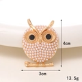 Detailed view of owl brooch with white pearls and black gemstone eyes on golden branch - Golden Pearl Owl
