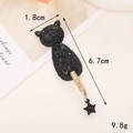 Detalle macro de dije de gato con diamantes negros, cola dorada y colgante de estrella - D521 Colgante Gato Strass (Negro)