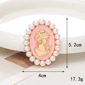 Macro detail of vintage pink cameo brooch with gold relief profile and white pearls - Pink Cameo