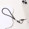Detail of luxury black rhinestone phone strap with silver ring on white wavy case - Black
