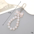 Iridescent white beaded bow keychain accessory for phone cases, 11cm length and 13g weight - K3728 Mermaid Bow Charm (Orange Clasp)