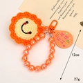 Handmade crochet sunflower keychain with orange beads and lucky charm tag - Beaded Smiley Face Style