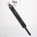 Detail of a black leather wrist strap with gold metal buckle on a white fabric background - Black (Without Rivets)
