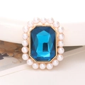 Macro-opname van rechthoekige blauwe kristallen grip met parelrand op gouden basis - Pauwblauw Edelsteen Stijl (D2008)