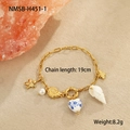 Dettaglio del bracciale oceano in oro 18 carati con stella marina e perla su sfondo sabbia - Bracciale Conca (NMSB-H451-1) / Oro 18K