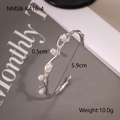 Detail of silver stainless steel open bangle featuring 5 pearls and wavy texture - Silver Pearl Style