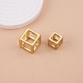 Macro shot of two hollow gold cube charms with geometric minimalist design on pedestals - 15mm / Gold