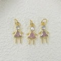 Macro shot of three gold-plated girl-shaped pendants with pink triangular zirconia stones - Pink Pendant