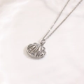Dettaglio macro del ciondolo a conchiglia in argento con accenti di stelle marine - Collana Conchiglia di Mare Argentata (ZYN-DMK1237P-A)