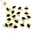 Dettaglio macro di ciondoli placcati oro a forma di occhio con pietra nera per gioielli DIY - Nero
