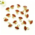 Dettaglio macro di gemme arancioni a navette con castone dorato per gioielli DIY - Rosso