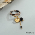 Detail van een open ring met luipaardprint en hangende bedeltjes van een hart en zon - Luipaard Hart Tassel Ring (NMSR-K613-2) / 18K goud