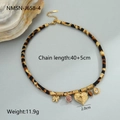 Detail van luipaardprint ketting met gouden hart en bloem hangers op grijs - Getextureerde Hart Etnische Halsketting (NMSN-J658-4) / 18K goud