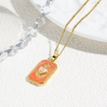 Detail view of a vintage tarot heart pendant with orange glitter and a gold bead chain - Orange Sacred Heart Style (ZYN-DMK945G-A1)