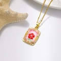 Détail du pendentif fleur en émail rose avec perle et chaîne dorée sur fond blanc - Collier Rectangulaire Fleur Rouge Fond Rose (ZYN-DMK987G-3A)