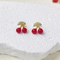 Macro shot of cherry earrings with red enamel and gold plated leaves set with zircons - Inlaid Cherry Studs (ZYN-DME694G)