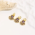 Detailed macro of 18k gold plated dog paw pendants with purple heart-shaped zircons - Purple