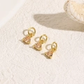 Close-up of three triangle champagne zircon charms with golden plating for DIY jewelry - Champagne