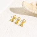 Macro shot of three triangular yellow zircon pendants with gold plated hoops for DIY jewelry - Gold