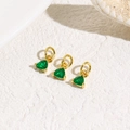 Detailed view of three emerald green triangle zircon charms with gold plating for jewelry - Green