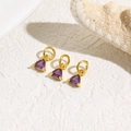 Three gold triangle pendants with purple zircon stones on a white textured background - Purple
