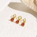 Detailed close-up of three triangle red zircon charms with gold metal base for DIY jewelry - Red