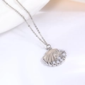 Detail van zilveren schelphanger met zeester-reliëf en witte parels aan een schakelketting - Witte Imitatieparel Schelp Met Halsketting