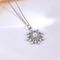 Detailaufnahme des Schneeflocken-Anhängers mit großer Perle und funkelnden Diamanten - Silber Schneeflocke Halskette Set