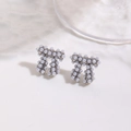 Détail de boucles d'oreilles nœud argentées ornées de perles blanches scintillantes - Boucles d'Oreilles Blanches (ZYN-DME749P)