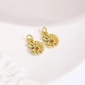 Macro-opname van gouden nautilus-bedeltjes met rode zirkonia voor DIY-sieraden maken - Oranjerood