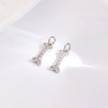 Close-up of bone-shaped silver charms with sparkling pavé zircons for DIY jewelry - White Bone